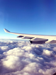 Clouds and sky and Airplane Wing as seen through window of an aircraft.