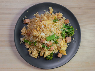 A plate of fried rice with pork and broccolini.