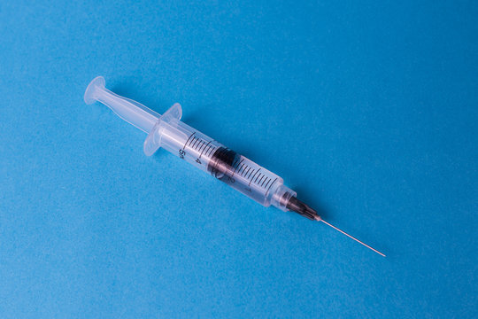 jeringas farmacos y pastillas sobre un fondo amarillo