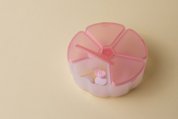 Pastillero con farmacos pastillas y medicina sobre un fondo amarillo