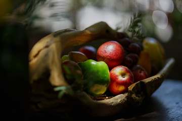 A series of colorful fruits set on a wooden table.