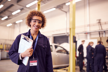 Fototapeta premium Portrait Of Female Tutor With Safety Glasses Teaching Auto Mechanic Apprenticeship At College