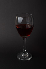 hermosas copas de vino transparentes con vino tinto sobre un fondo negro