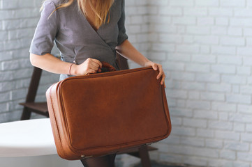 woman with brown suitcase in hands