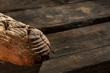 Fresh baked bread at brown wooden table. brown coarse grain bread.