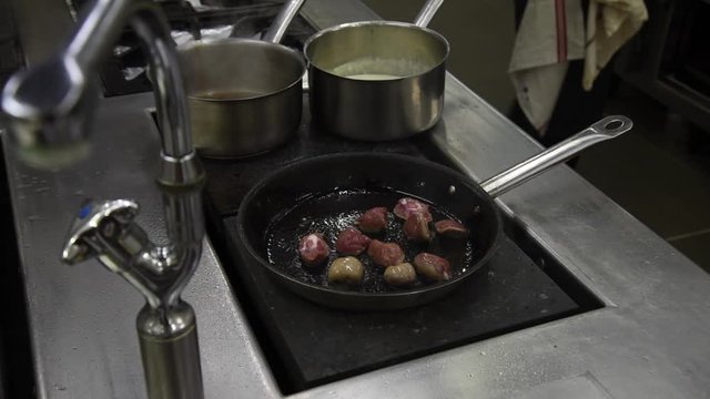 Cuisson de rognons dans une po&ecirc;le dans une cuisine professionnelle de restaurant