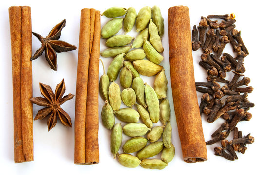 Przyprawy korzenne: anyż, cynamon, kardamon i goździki na białym tle