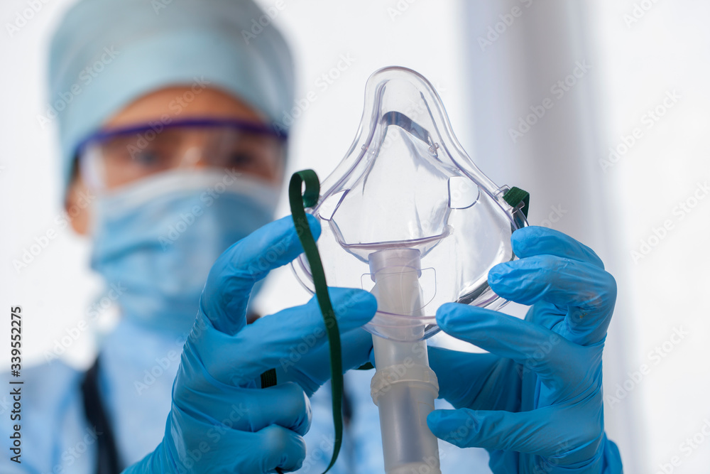 Wall mural doctor in protective equipment put on oxygen mask patient diagnosis of coronavirus