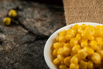 Marinated corn seeds in a white saucer on a piece of burlap