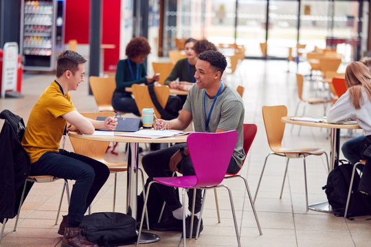 Communal Area Of Busy College Campus With Students Working At Tables