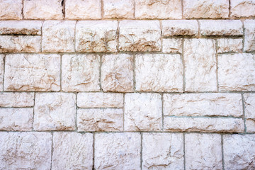 Eine alte verwitterte weiße Steinmauer als ein Hintergrund