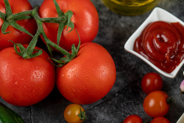 Fresh red tomatoes and ketchup sauce,top view