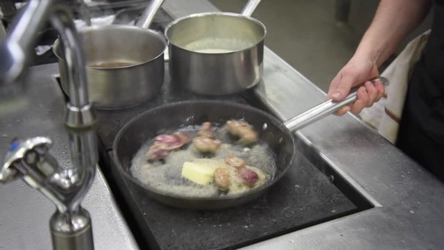 Cuisson de rognon au beurre dans une poele dans une cuisine professionnelle 