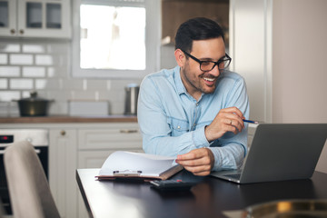 Fototapeta na wymiar Young man doing paperwork and using laptop.