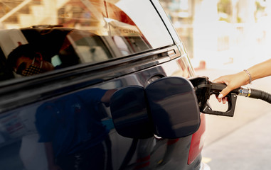Male hand fill up petrol tank gasoline fuel petrol in car being filled with fuel at gas petrol...