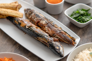 Nigerian fried food dish. Grilled fish with plantain. Nigerian cuisine.