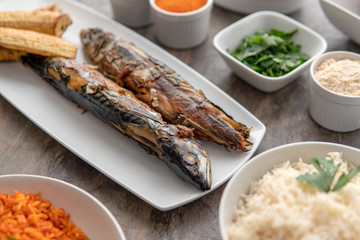 African national fried food dish. Grilled fish with plantain. Nigerian cuisine.