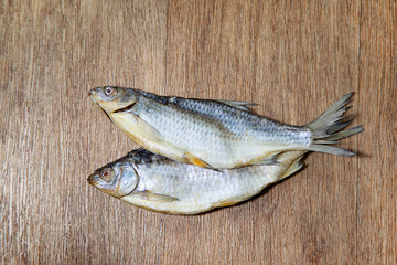 two dried fish on a wooden background for your design or beer bar menu