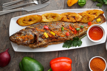 Nigerian fried food dish. Grilled fish with plantain. Nigerian cuisine.