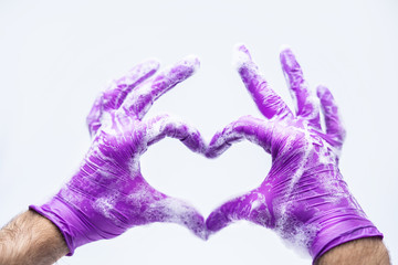 Hands in gloves soapy heart symbol