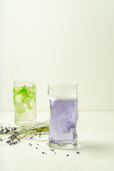 Two glasses of summer refreshing drinks, lavender lemonade and cucumber infused water