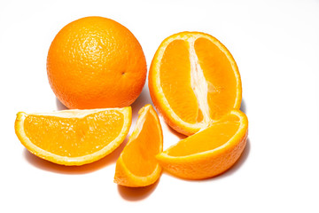Oranges on white background. Pieces of oranges and whole oranges, with little shadow. Groups of oranges on white