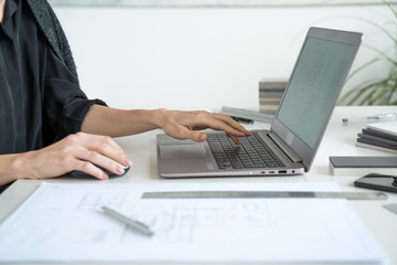 The interior designer sworks behind a laptop. Designer at work. Architect desk. Decoration. Design project blueprints. Plans and drawings. Grey stone. Decorative material. Flatlay. Work from home. 