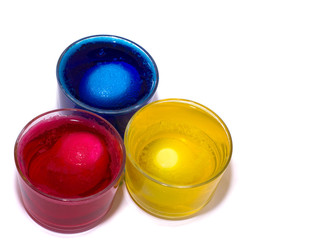 the Process of painting eggs in red, yellow, blue. Preparing for the Easter holiday.