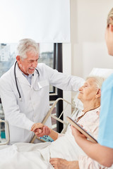 Chefarzt tröstet eine kranke Seniorin