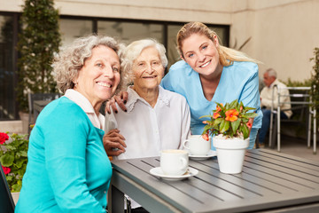 Zwei Senior Frauen und eine Pflegehilfe
