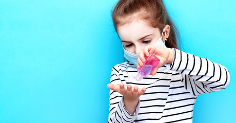Child is holding bottle of medical sanitizer gel for skin sterilization. Little girl use sanitizer...