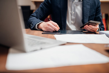 Close up man designer sketching using smartphone and graphic tablet