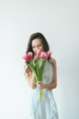 Girl with pink tulips on the background. Woman and tulips