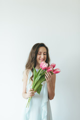 Beautiful girl hugging bouquet of pink tulips, girl and tulips