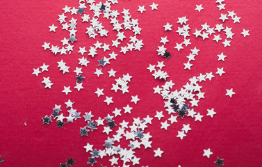 Holiday background with little silver stars on red background