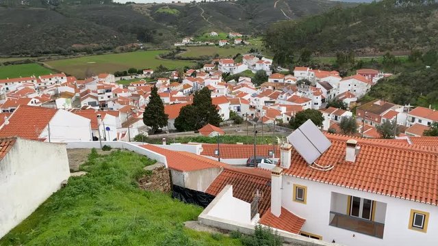 Panning, establishing shot of the famous orange rooftops of Odeceixe, Portugal