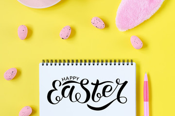 Easter holiday background with notebook and pen, cup for coffee, bunny ears and easter eggs