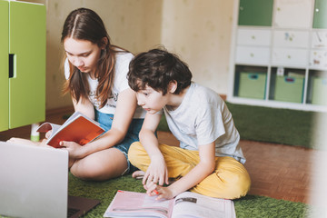 Siblings brother sister attractive girl teenager and tween boy do homework learn foreign language...
