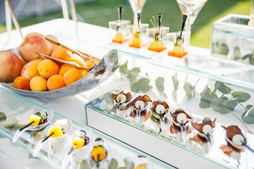 on a wooden table in the wedding banquet area are snacks, fruits, sweet cakes and muffins and lemonade drink
