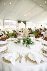 banquet table is decorated with plates, cutlery, glasses, candles and flower arrangements