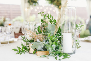 banquet table is decorated with plates, cutlery, glasses, candles and flower arrangements