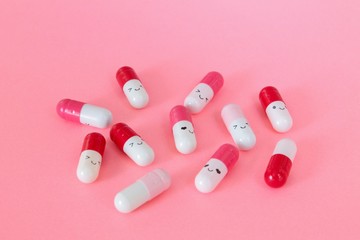 Smile pink pills close-up isolated on pink background. Antidepressant concept