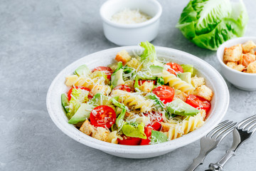 Fusilli pasta salad with avocado, tomatoes, fresh green lettuce, parmesan cheese and croutons