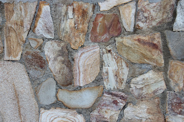 background of a solid stone wall or floor made of cement, limestone, sand and old multi-colored cobblestones similar to marble with an uneven surface, of different sizes and shapes