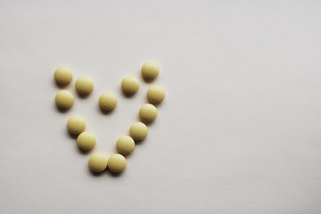 pills in the shape of a heart on white