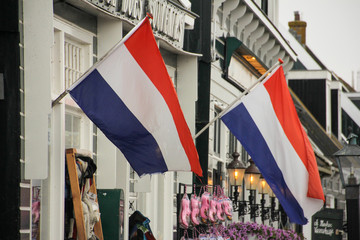 Two Dutch flags waving on the front of a house