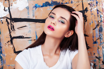 young brunette woman with fashion makeup on painted background, lifestyle people concept