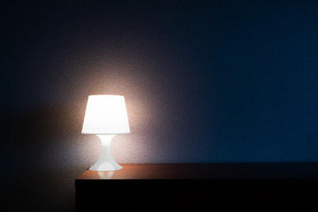 A lamp shines over the bed. The lamp in the bedroom. Home lighting.