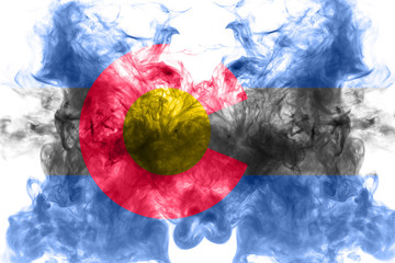 The national flag of the US state Colorado in against a gray smoke on the day of independence in different colors of blue red and yellow. Political and religious disputes, customs and delivery.
