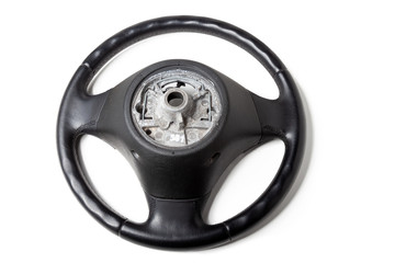 Black leather shiny steering wheel with a metal frame a separate part of the car on a white isolated background in the workshop prepared for installation and repair of the chassis.